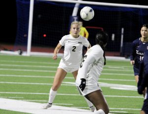 Senior Grace Robertson heading the ball to clear